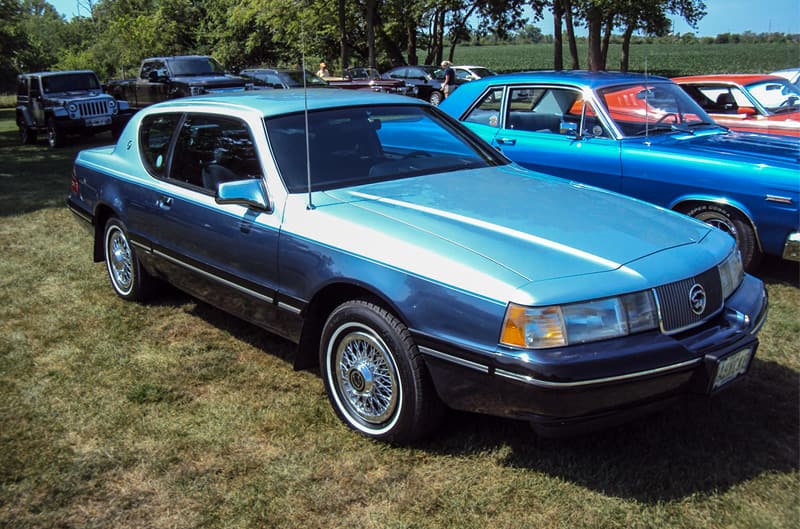 Front profile of a light blue Mercury parked on the grass