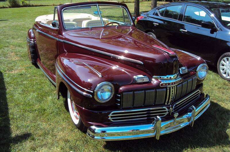 Front of a classic red Mercury convertible parked on the grass