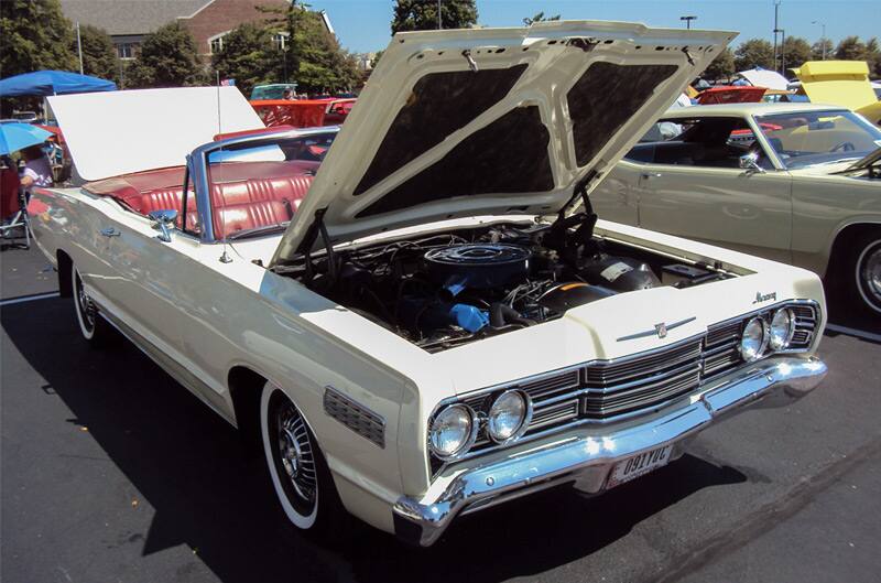 Front of a white Mercury Convertible with hood and trunk open in parking lot