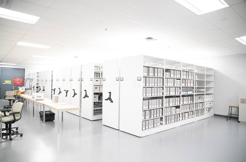 Various white bookcases holding files in an office