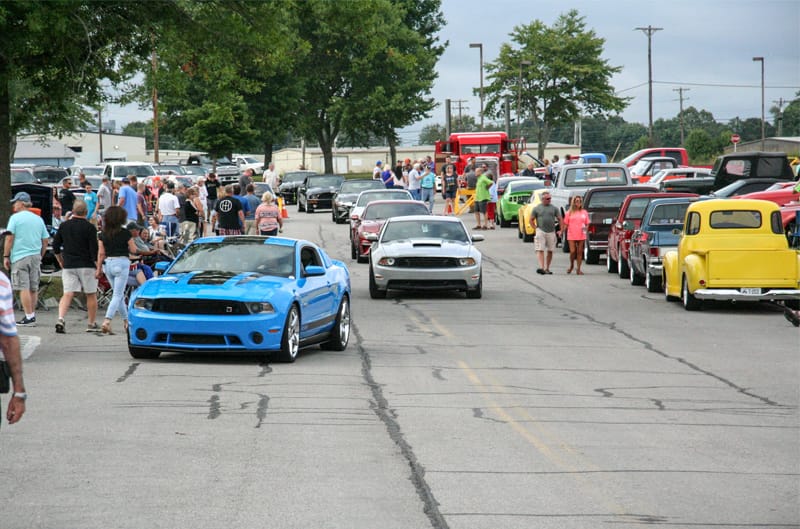 A lineup of Mustangs driving throught the display of vehicles