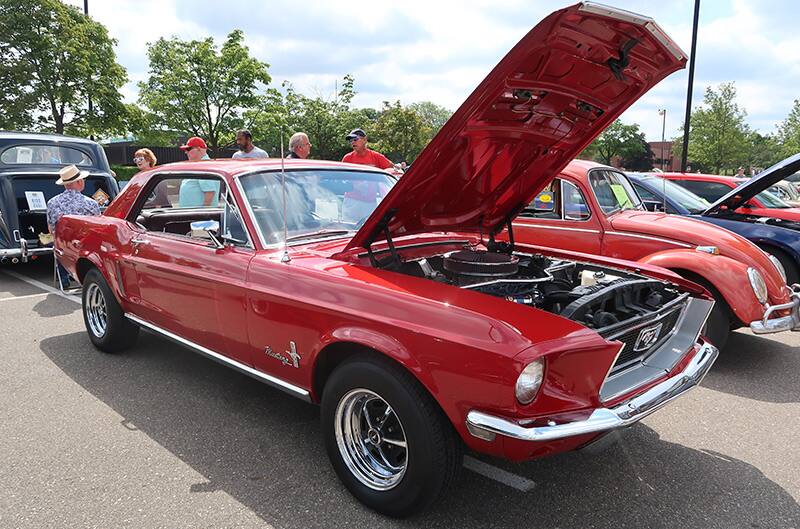 A front side view of a classic red Mustang on display