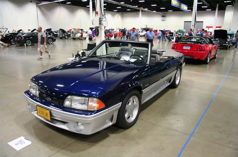 Front profile of a blue Mustang convertible in garage