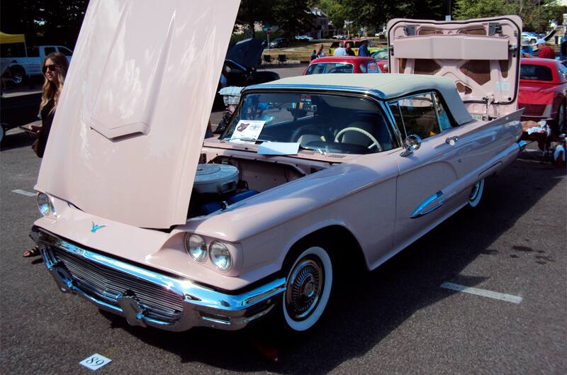 Front of light pink Thunderbird with hood and trunk open in parking lot