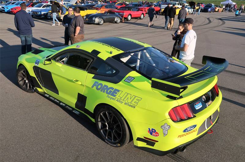 Rear profile of a neon yellow Shelby Mustang in parking lot