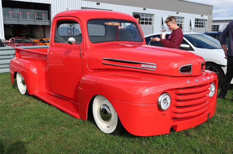 Front profile of a classic red Ford pickup truck parked on grass