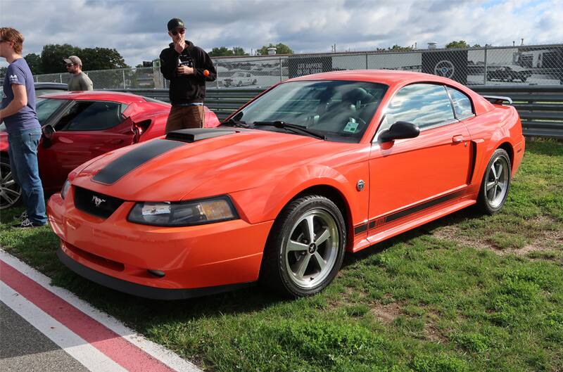 Front profile of a red Mustang parked on the grass