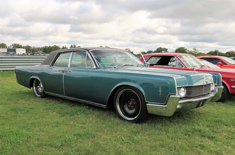 Front profile of a green Lincoln parked on grass