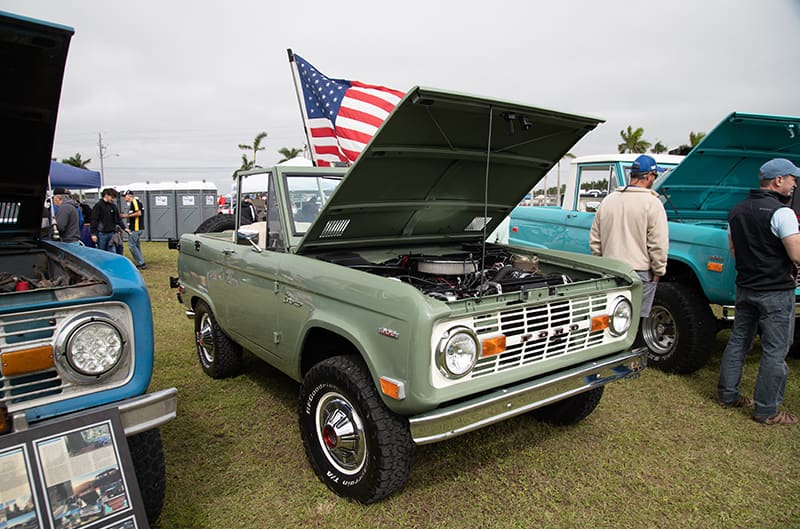 A front side view of a green Ford Bronco on display