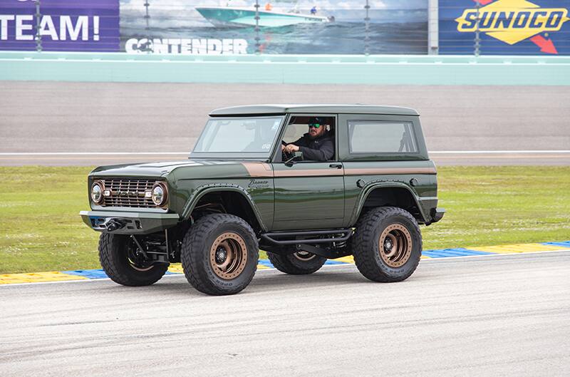 A man driving a green Bronco on the track at Homestead
