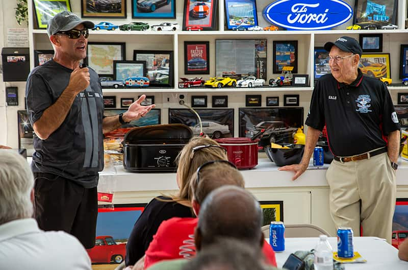 Two men speaking in front of shelves of diecast Fords