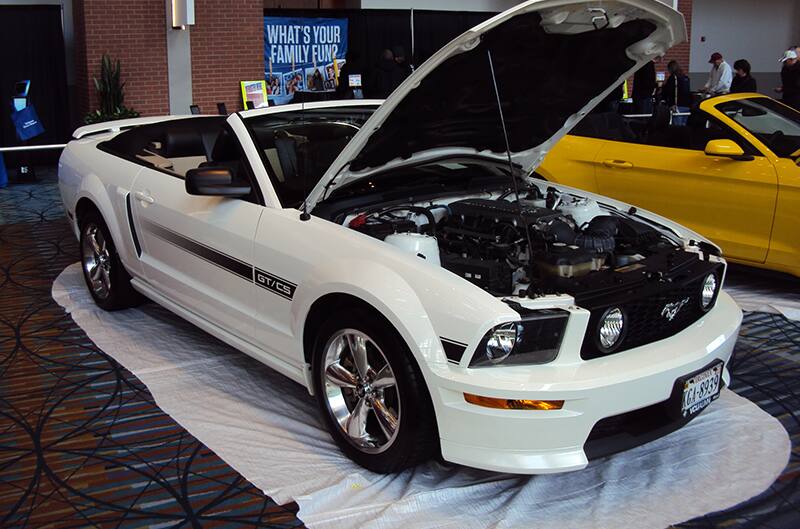 Front profile of a white Mustang GT convertible with hood open