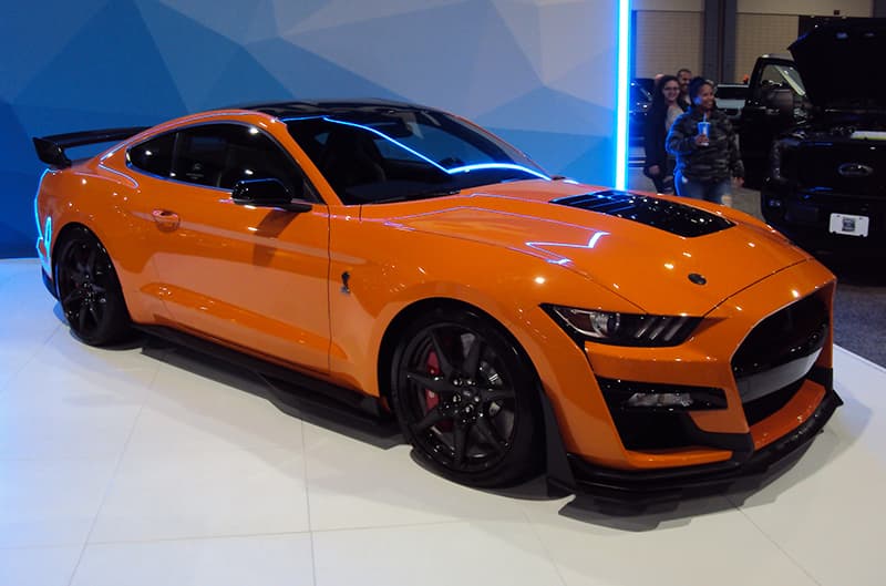 Front profile of an orange Shelby Mustang on display