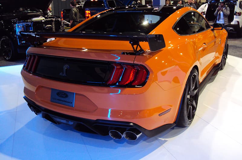 Rear of an orange Shelby Mustang on display