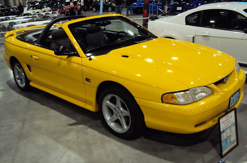Front profile of a yellow Mustang convertible on display