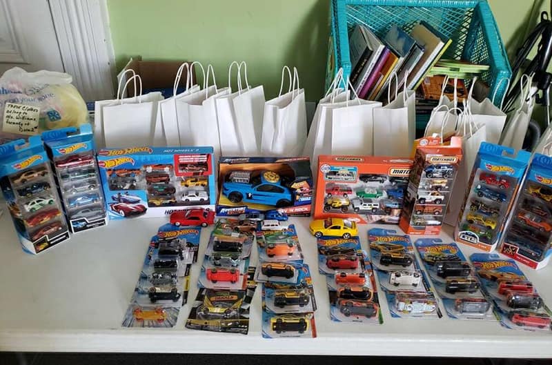 Table full of various toy cars and gift bags