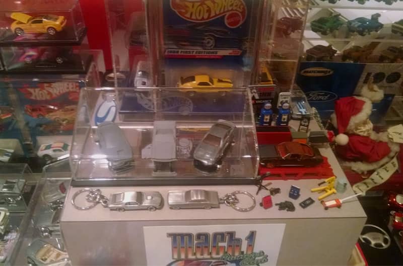 Display case and table with various Mach 1 toy cars