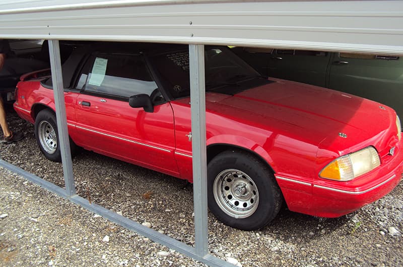 Red Foxbody convertible mustang under covered car shelter