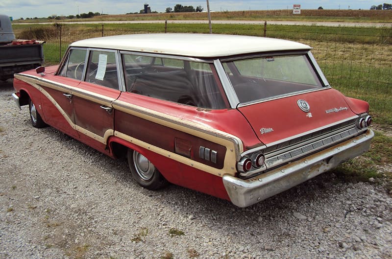 Station wagon sitting outside with dull paint, photo from driver side rear