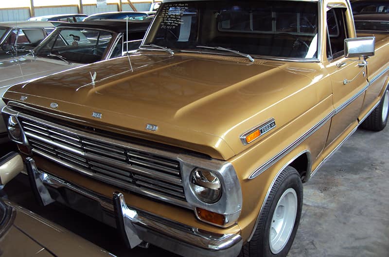 Gold Ford pickup parked among other vehicles