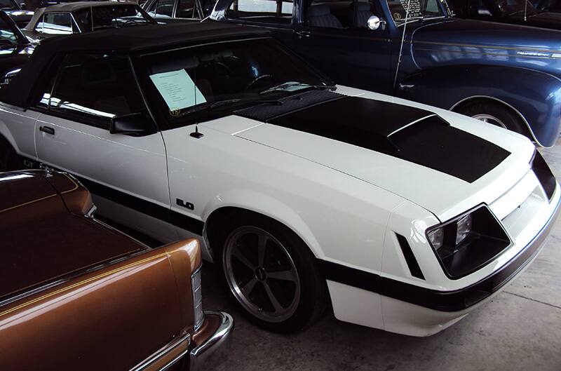 White Mustang Foxbody with black stripes and Mach 1 wheels