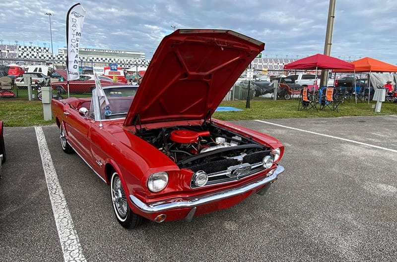 Red 1960s Mustang convertible with hood open