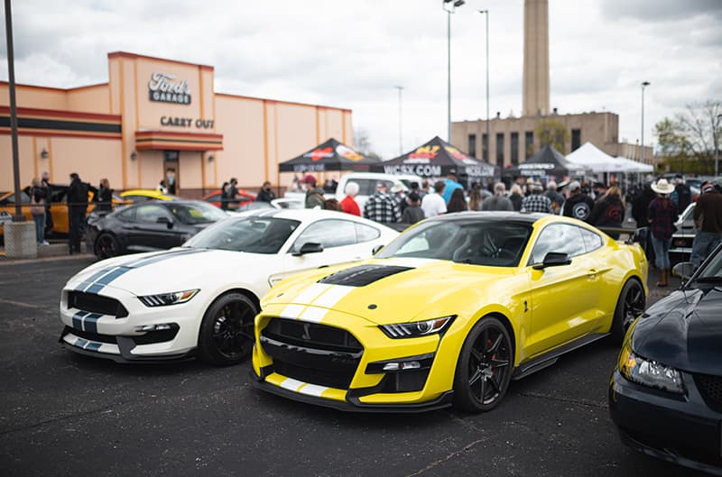 Grabber Yellow GT500 and white GT350 Mustang parked at Fords Garage