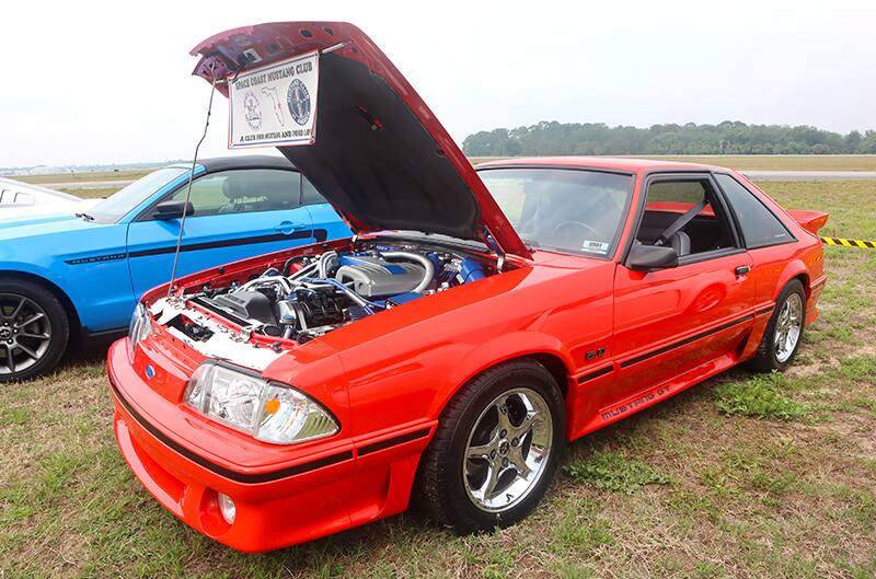 Red Foxbody mustang with hood open at Show