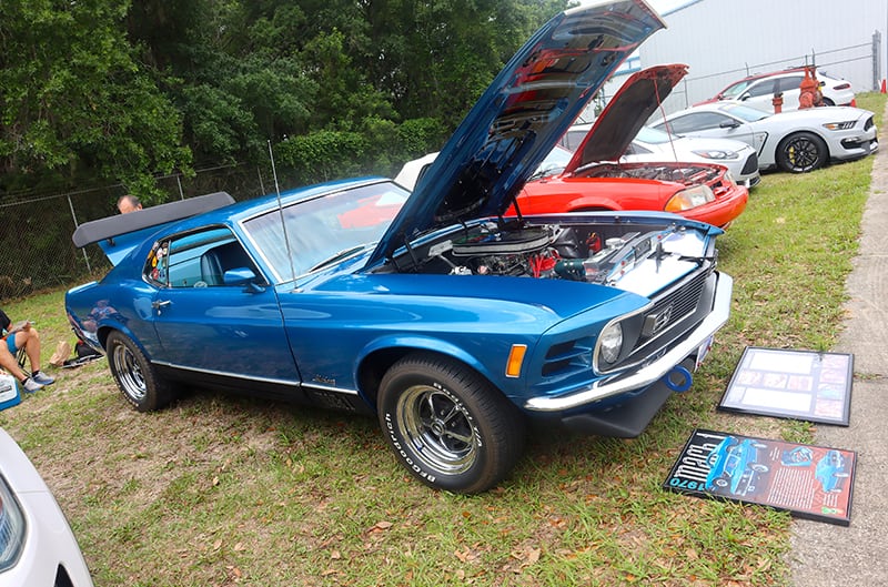 Light blue 1970 Mustang with hood and trunk open at car show