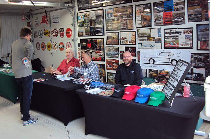 Mustang Authors sitting behind table inside museum