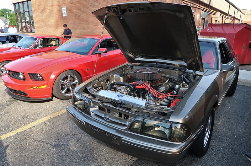 Foxbody mustang with hood open focus on engine bay