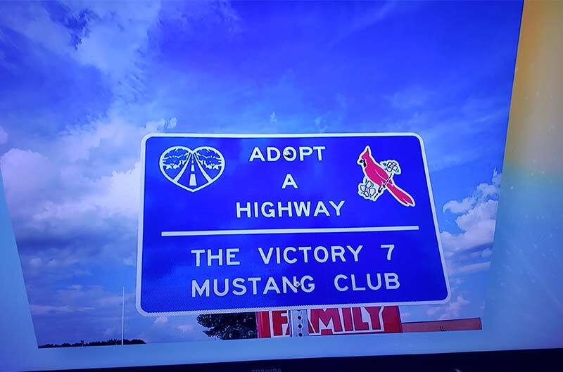 Highway sign with mustang club name on it