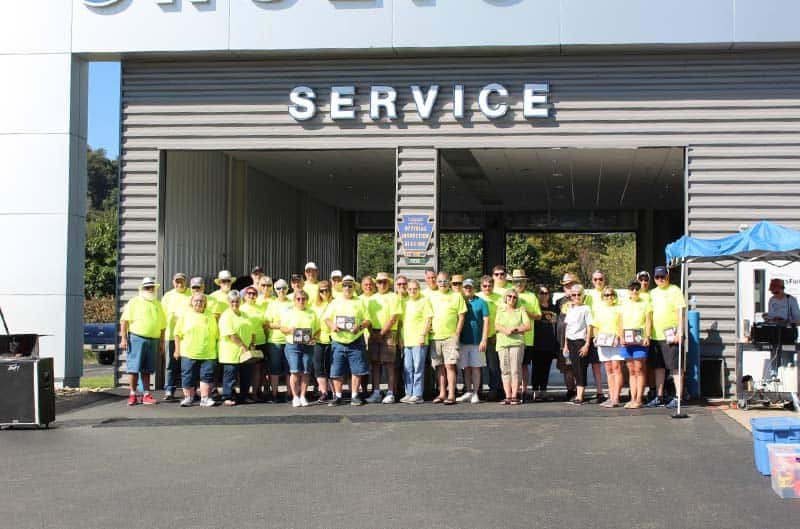 Mustang Club standing in front of service bay