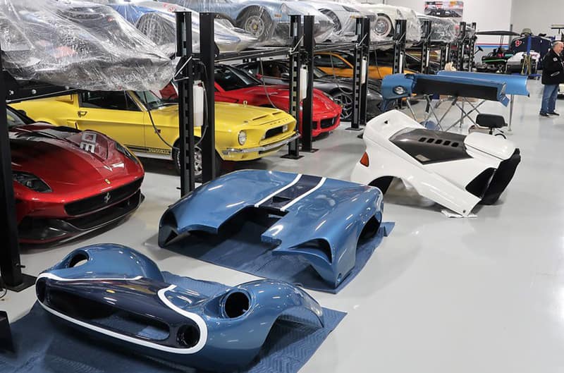 Body kits sitting on the floor with cars in background