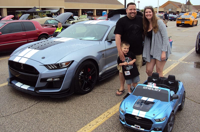 Family standing with GT500 S550 Mustang and powerwheels GT500