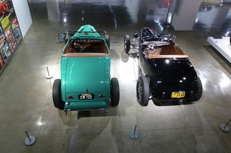 Two 1930s Fords in museum under spotlights