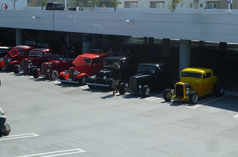 many 1930s ford lined up in parking lot of petersen