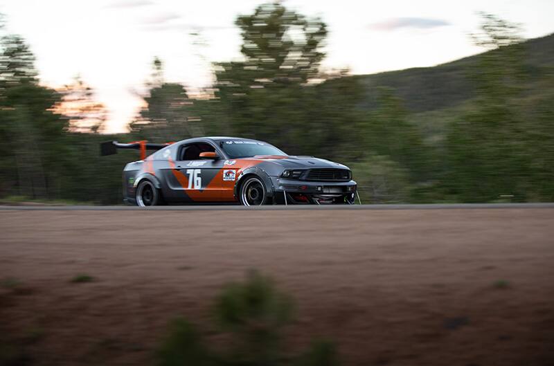Grey and orange mustang at speed on course