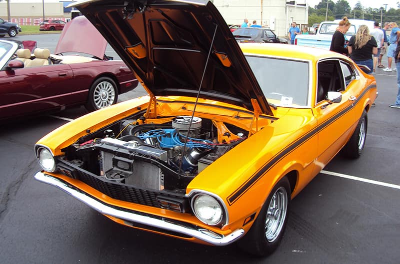 Orange Ford maverick with hood open