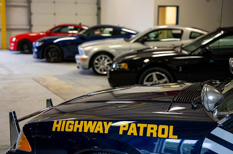 Several mustangs inside shop