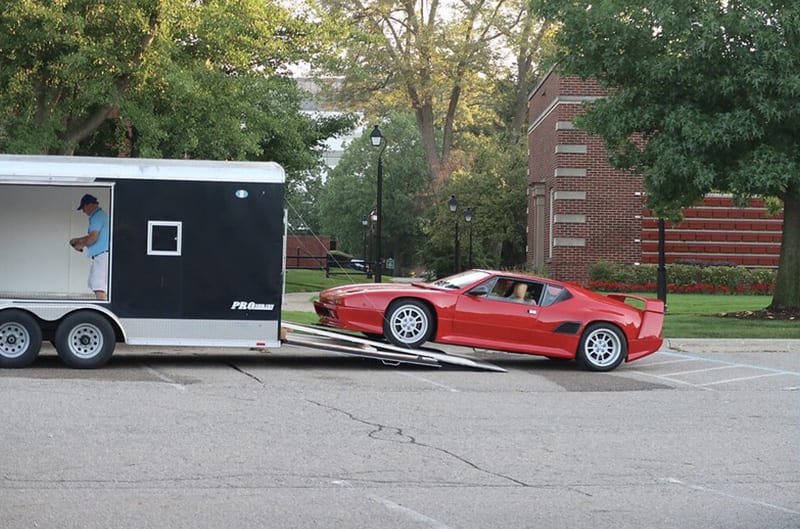 Red Pantera unloading from enclosed trailer