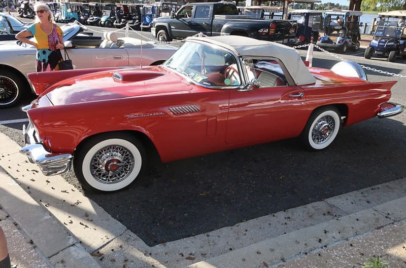 Red 60's ford thunderbird with white top and hood open