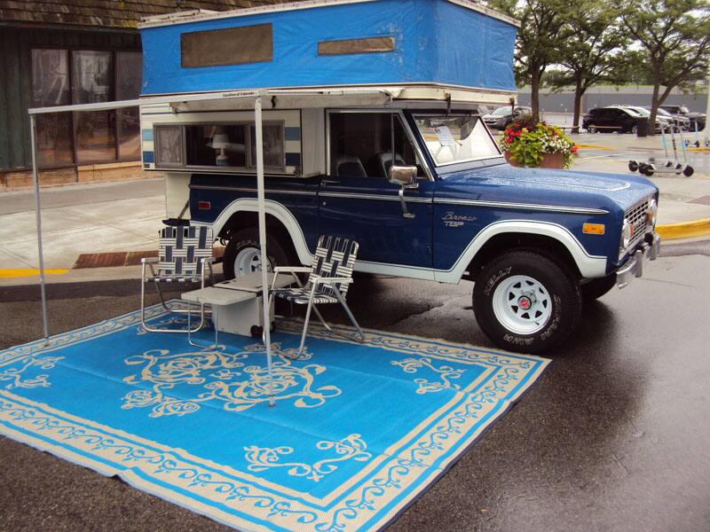 Ford Bronco on display with camper attachment and rug