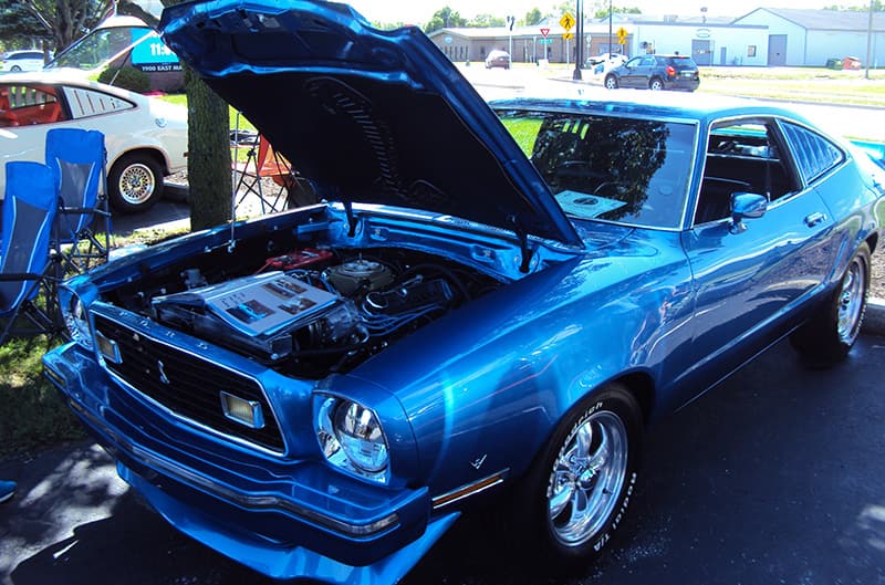 Blue Mustang II with hood open in the shade