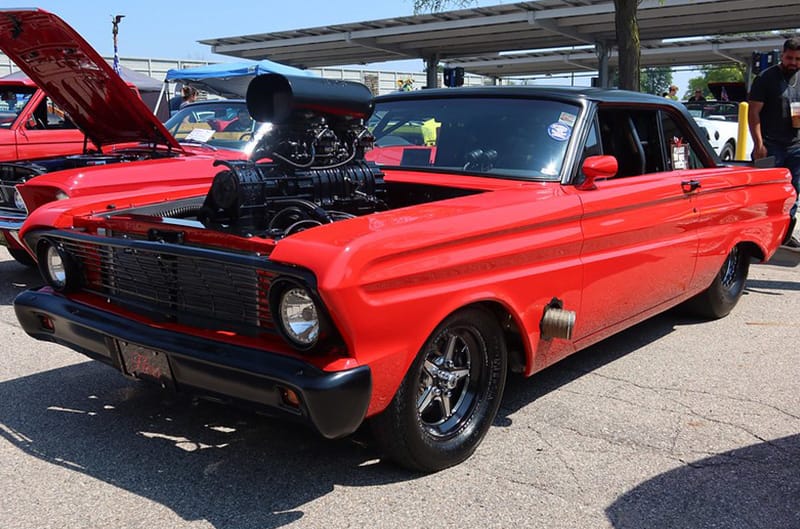 Red ford with large supercharger sticking out of the hood