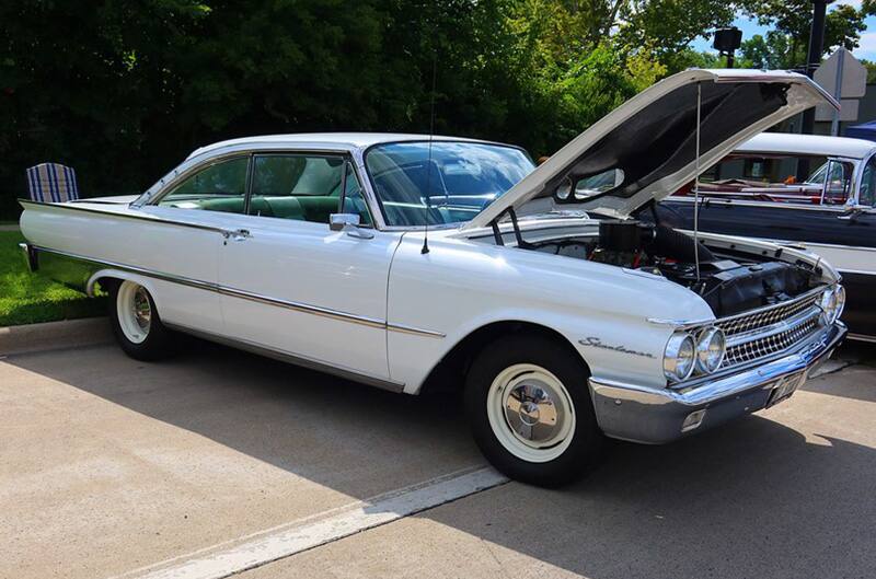 White ford with hood open on display