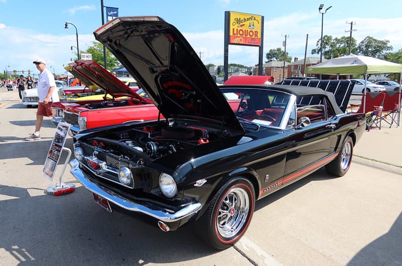 Black first generation Ford Mustang with black convertible top