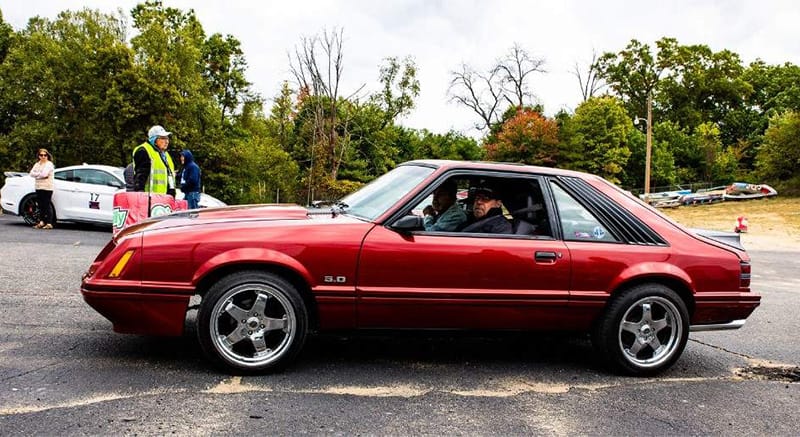 Red Foxbody mustang pulling into show