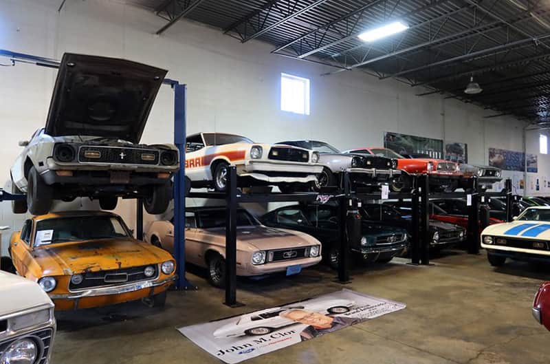 Many Mustangs in storage on lifts