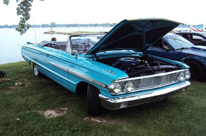 convertible ford in blue near the water